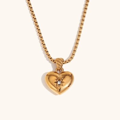 18k gold celestial starburst heart necklace with a central zircon stone on a durable box chain against a white background.