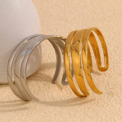 An angled shot of the 18k gold and white gold triple band cuff bracelets together, emphasizing their sleek, modern, and architectural design.