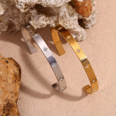 A close-up view of the 18k gold and white gold star cuff bangles, showing the sparkling cubic zirconia star details.