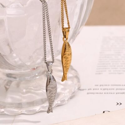 The sardine fish necklace shown in both 18K gold and polished silver finishes, hanging gracefully inside a clear glass bowl.